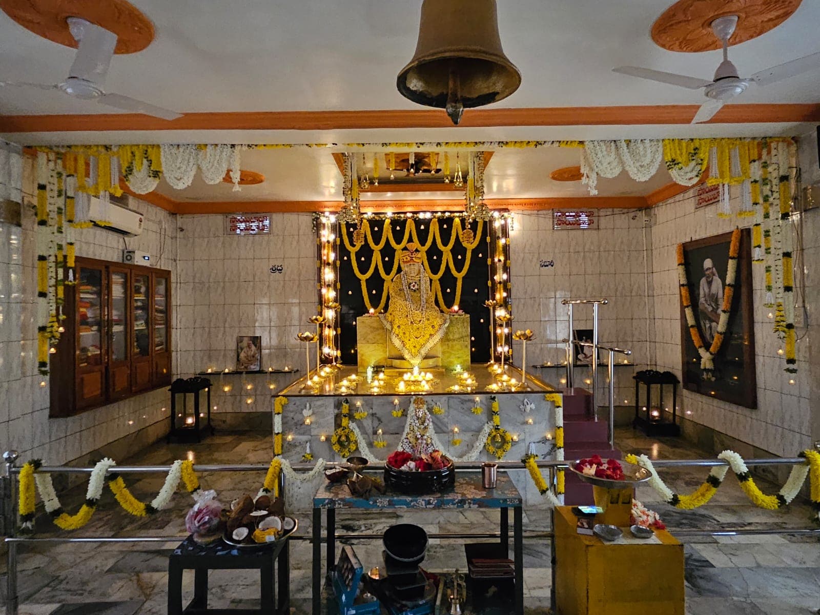 Inside the mandir, the bell hanging above the altar with the murti seated beyond